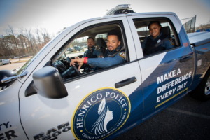 Three Henrico Police Officers in a henrico police truck looking at the camera